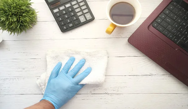 Person hand in disposable gloves clean table surface