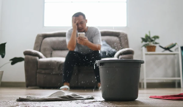 Stressed man calling home service to repair roof leak at home